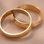 gold wedding rings on beige fabric background