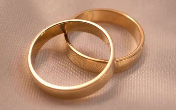 gold wedding rings on beige fabric background
